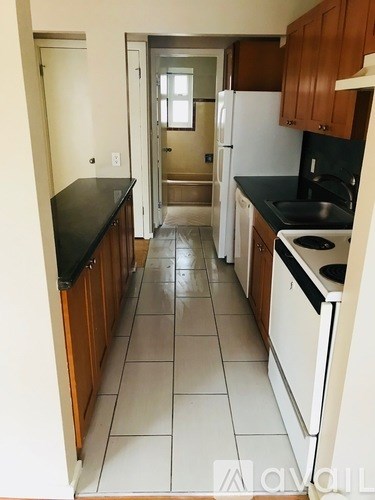 A kitchen with white appliances and wooden cabinets.