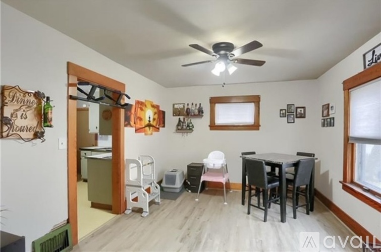 A room with a dining table and chairs.
