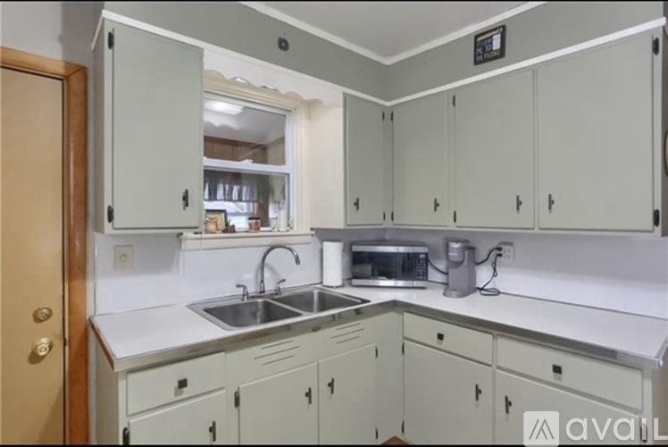 A kitchen with white cabinets and a sink.