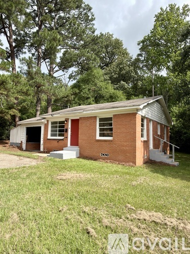 A red brick house with a white garage door and a white porch.