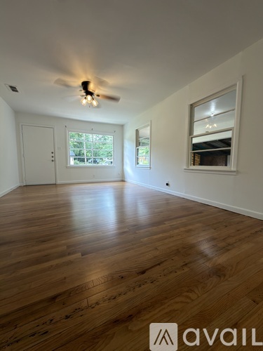 A room with wooden floors and a ceiling fan.