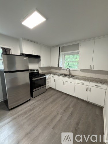A kitchen with a stainless steel refrigerator and white cabinets.