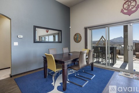 A dining room with a table and chairs and a mirror on the wall.