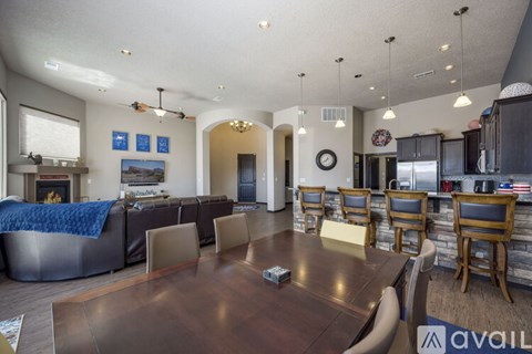 A modern living room with a large wooden table and chairs.