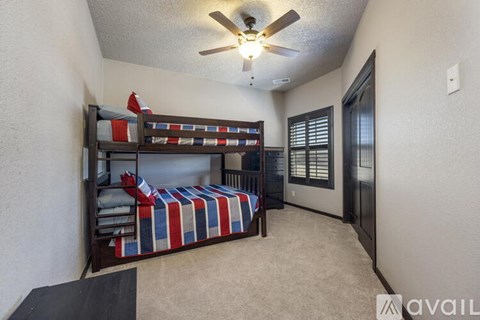 A bedroom with a bunk bed and a ceiling fan.