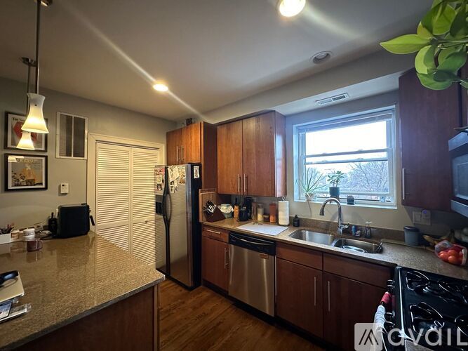 A kitchen with wooden cabinets and a stainless steel refrigerator.