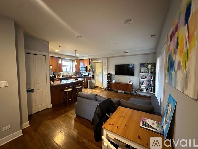 A living room with a couch, a chair, and a painting on the wall.