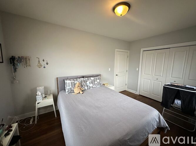 A bedroom with a bed, a nightstand, and a chair.