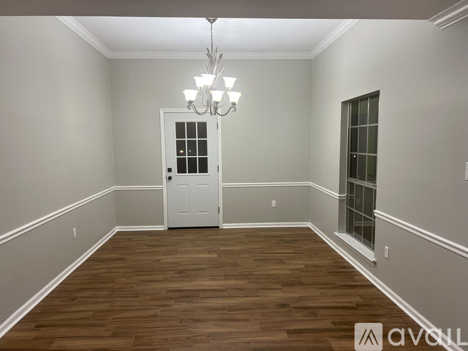 A room with wooden flooring and a white door.