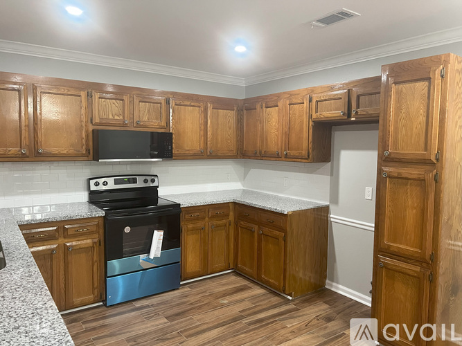 A kitchen with wooden cabinets and a black stove top oven.