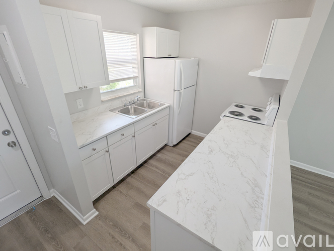 A kitchen with white cabinets and appliances.