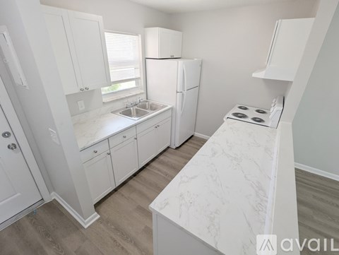 A kitchen with white cabinets and appliances.
