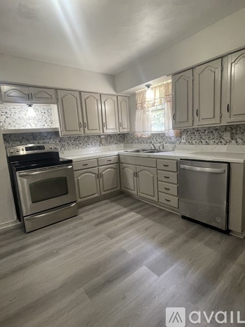 A kitchen with a stove, oven, and dishwasher.