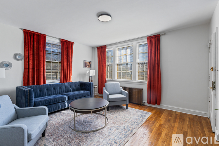 A living room with a blue couch, grey armchair, and a coffee table.