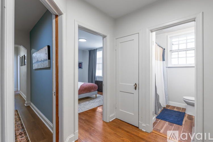 A hallway with a blue wall and a white door.