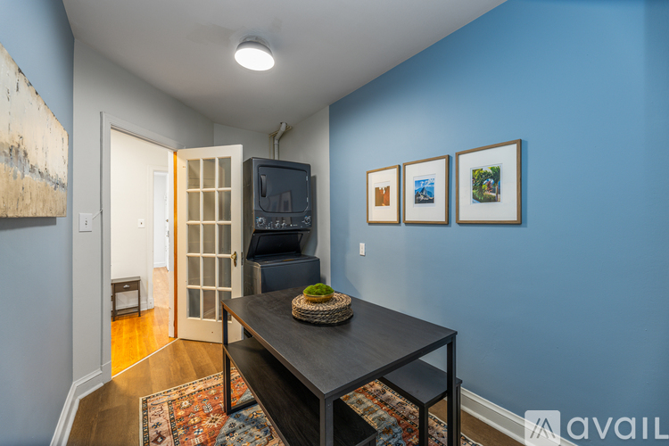 A room with a blue wall and a black table with a basket on it.