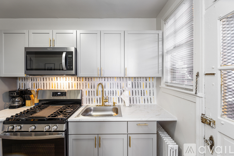 A kitchen with white cabinets and a black stove top.