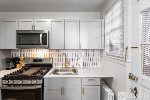 A kitchen with white cabinets and a black stove top.