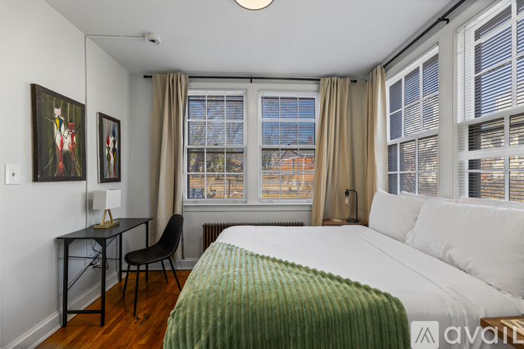 A bedroom with a bed, desk, and chair.