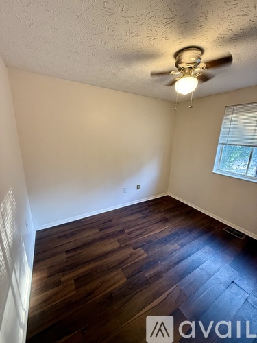 A room with wooden flooring and a ceiling fan.