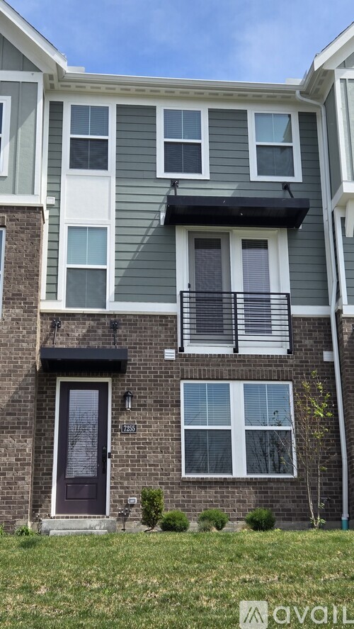 A brick building with a balcony and a window with blinds.