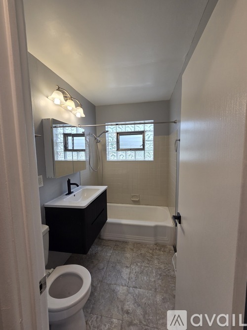 A bathroom with a toilet, sink, and bathtub.