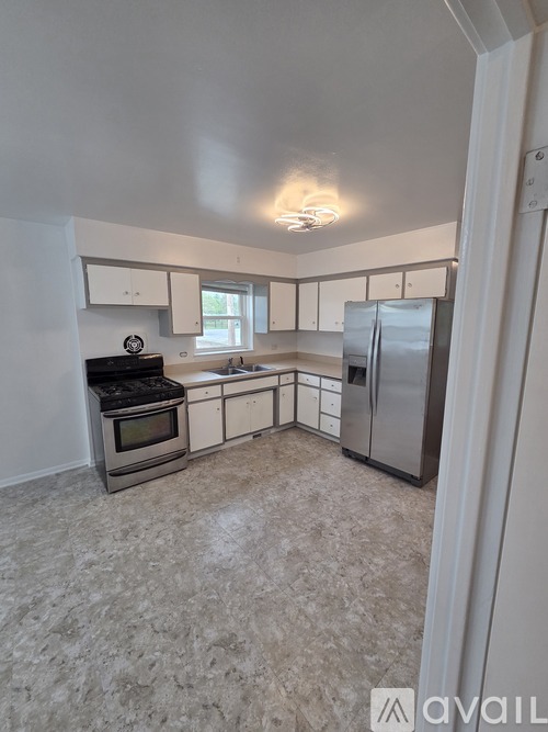 A kitchen with a refrigerator, oven, and microwave.