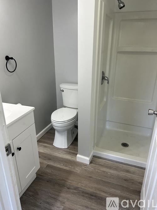 A white toilet sits next to a white sink in a small bathroom.