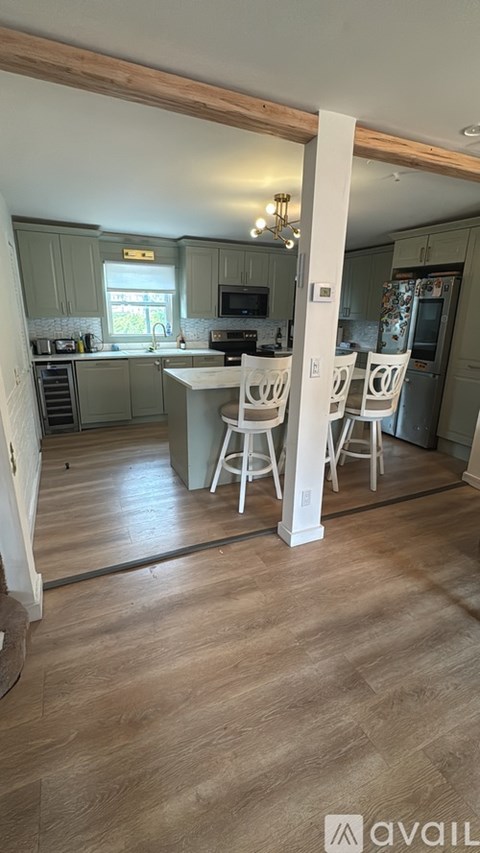 A kitchen with a dining table and chairs.