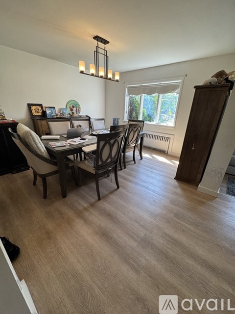 A dining room with a wooden table and chairs.