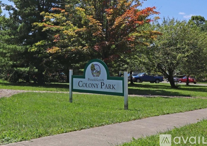 A green sign that says Colony Park stands in a grassy area.