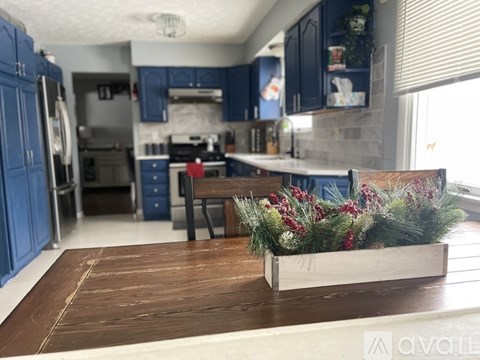 A kitchen with a table and a bench with a floral arrangement on it.