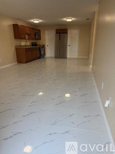 A kitchen with a marble floor and wooden cabinets.