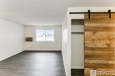 A room with a wooden wall and a window.