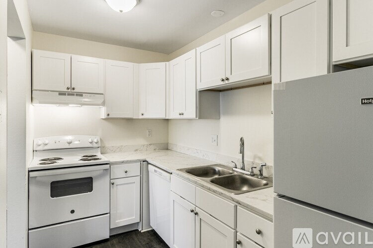 A kitchen with white cabinets and appliances.