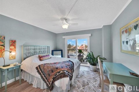 A bedroom with a bed, desk, and chair.