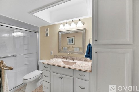 A bathroom with a toilet, sink, and mirror.