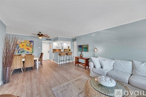 A living room with a white couch and a ceiling fan.