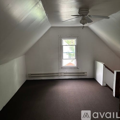 A room with a window and a ceiling fan.