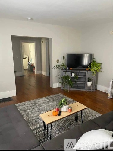 A living room with a grey couch and a wooden coffee table.