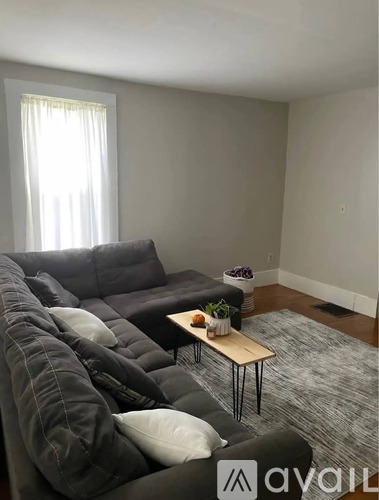 A living room with a grey couch and a wooden coffee table.
