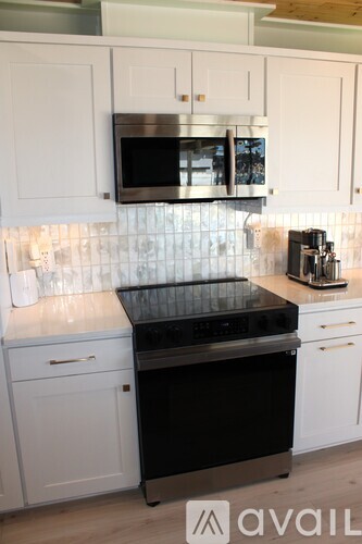 A kitchen with white cabinets and a black stove top oven.