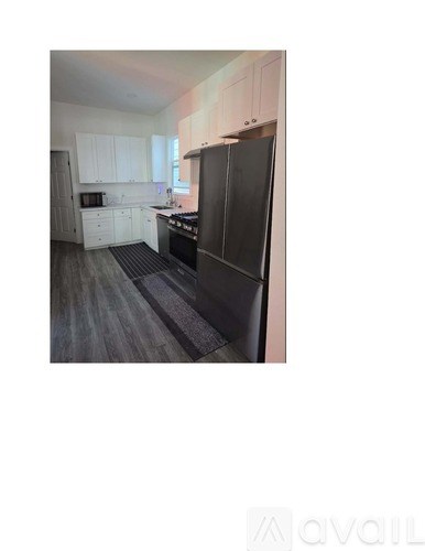 A kitchen with black appliances and white cabinets.