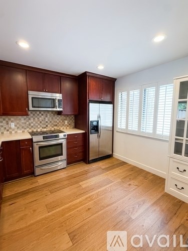 A kitchen with wooden cabinets and a checkered backsplash.