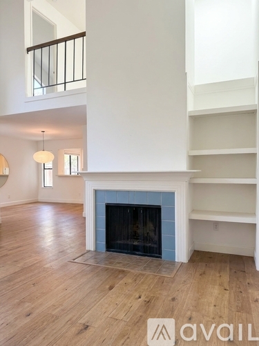 A living room with a fireplace and wooden floors.