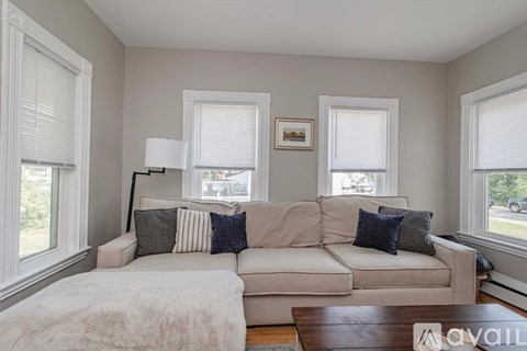 A living room with a white couch and a brown coffee table.