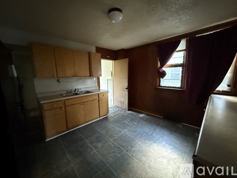 A kitchen with wooden cabinets and a tiled floor.