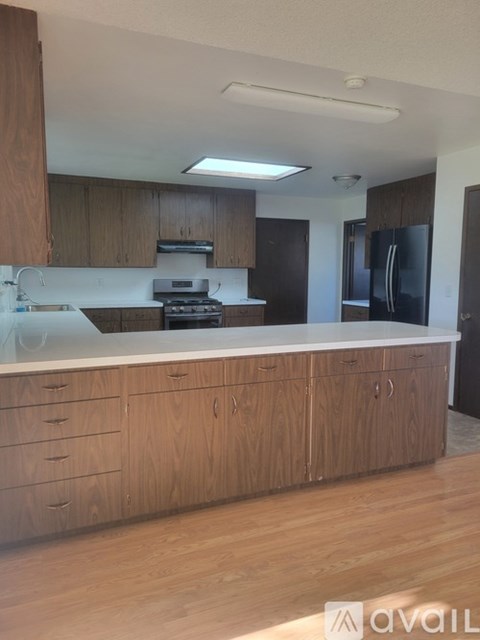 A kitchen with wooden cabinets and a white countertop.