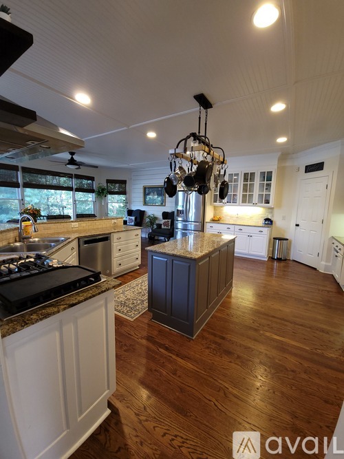 A kitchen with a wooden floor and a large island in the middle.