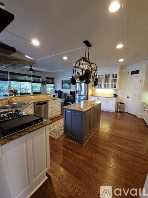 A kitchen with a wooden floor and a large island in the middle.